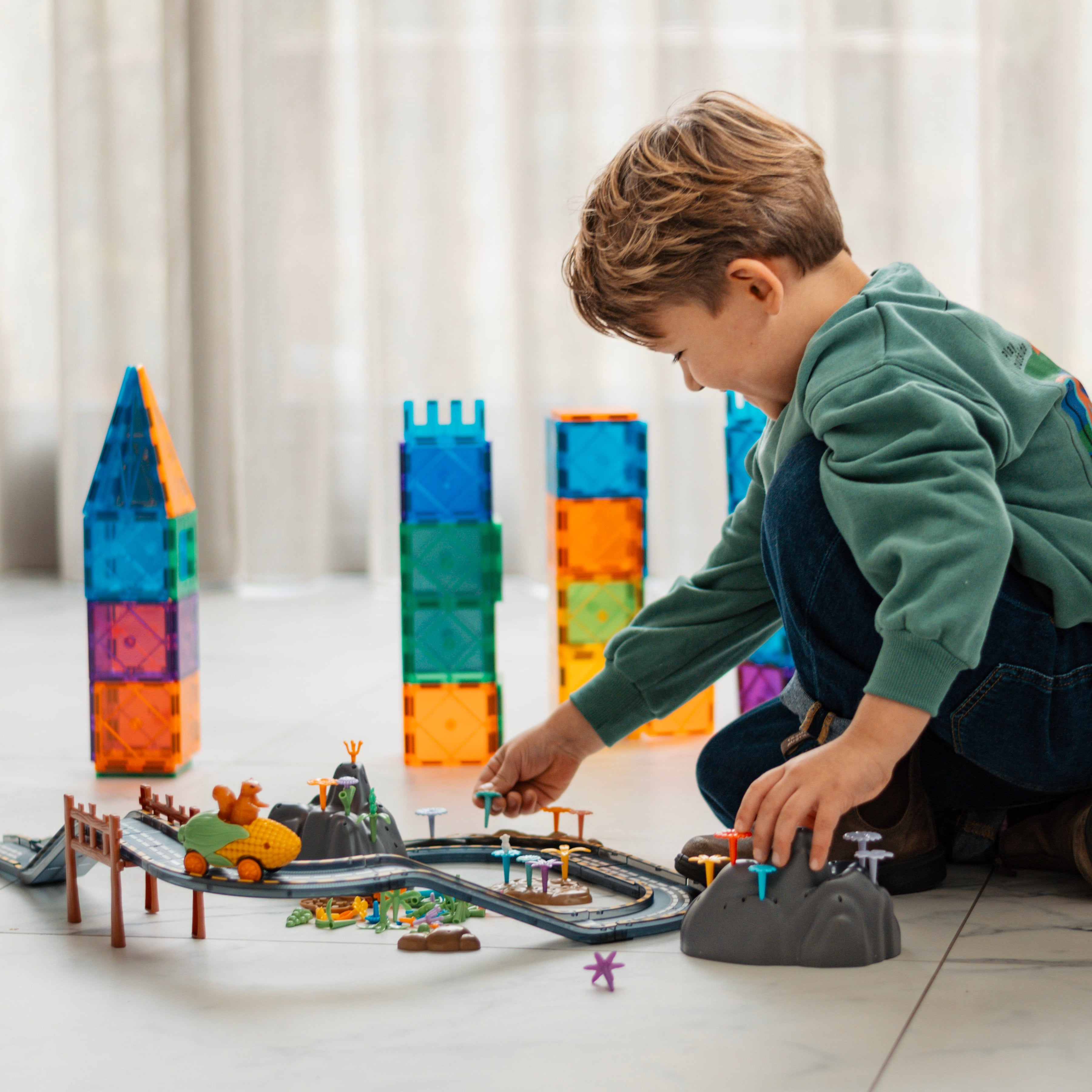 Jongen bouwt de magnetische racebaan op (orbit)